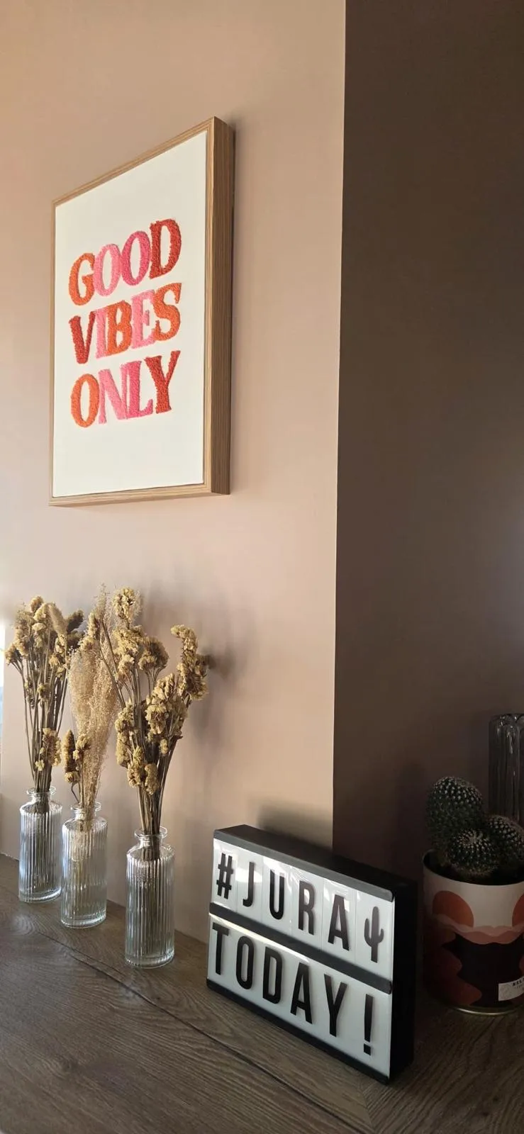 Décoration du JuRa avec l'affiche Good Vibes Only, des fleurs séchées et l'enseigne du bar
